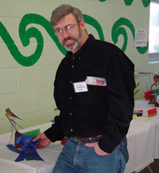 Kenny Jewell holding one of his carvings